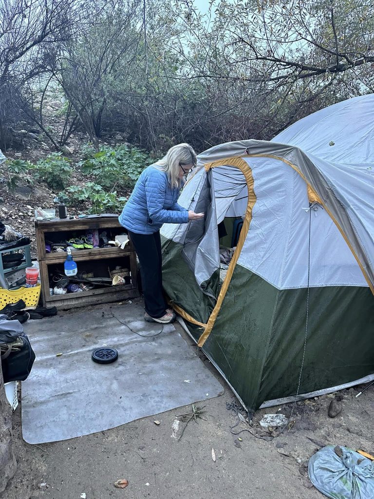 Supervisor Dawn Rowe looks into the tent of a homeless individual.