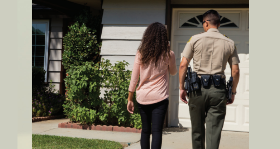 A county resident has a conversation with a Sheriff's Department representative while walking back to a house.