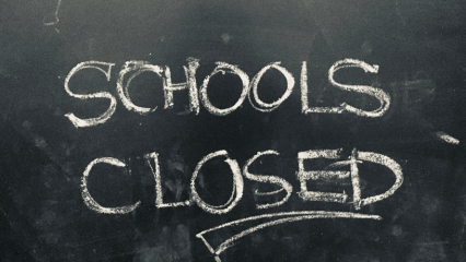 BLACKboard with the words SCHOOLS CLOSED written in chalk