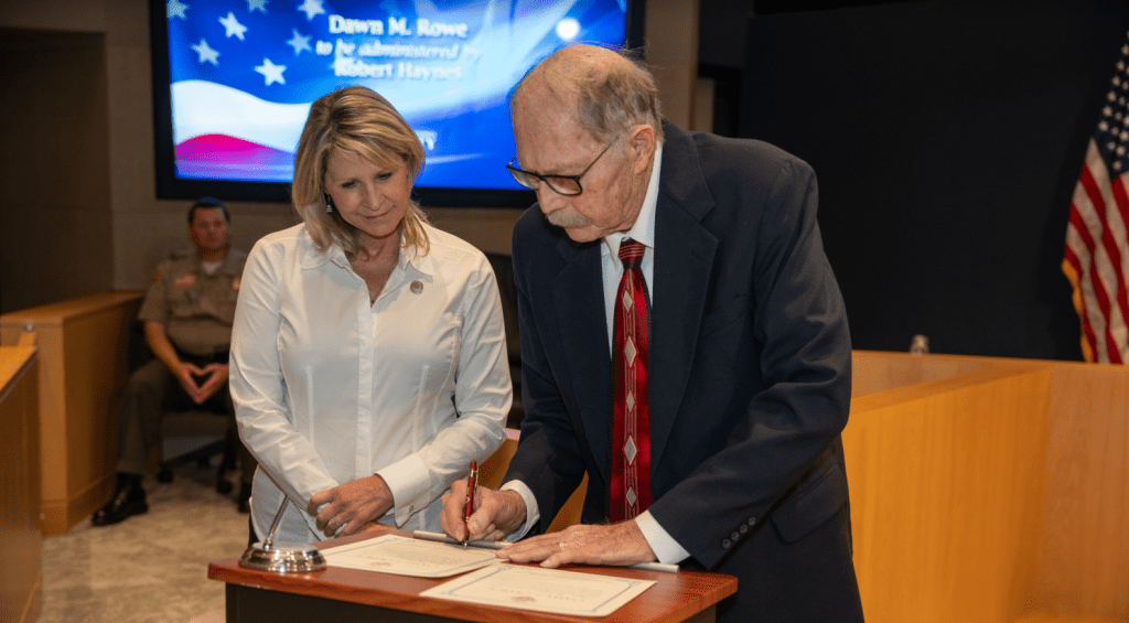 Supervisor Rowe and her father sign official paperwork