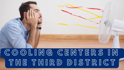 Man lays on floor with his head in his hands, facing a fan that is blowing--evidenced by the streamers attached.