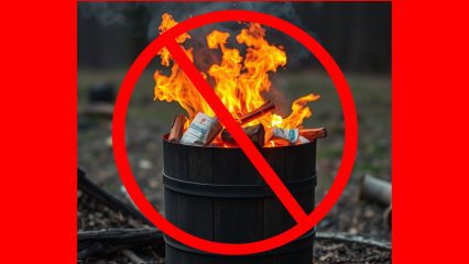 Trash burning in a barrel with a red "no" slash symbol emblazoned across it.